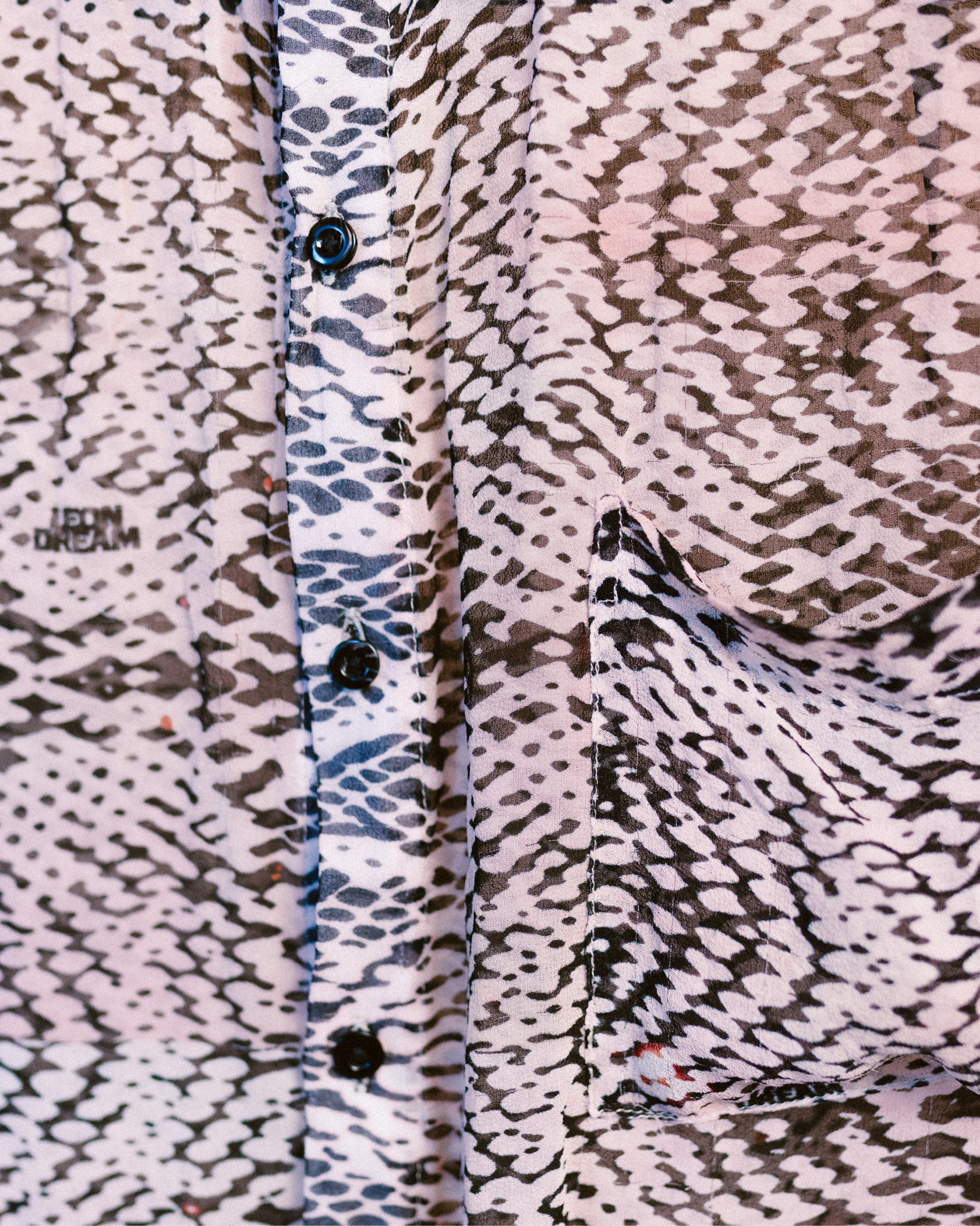 Close-up shot of the patterns of the Kaleidosnake silk chiffon shirt by Leon Dream